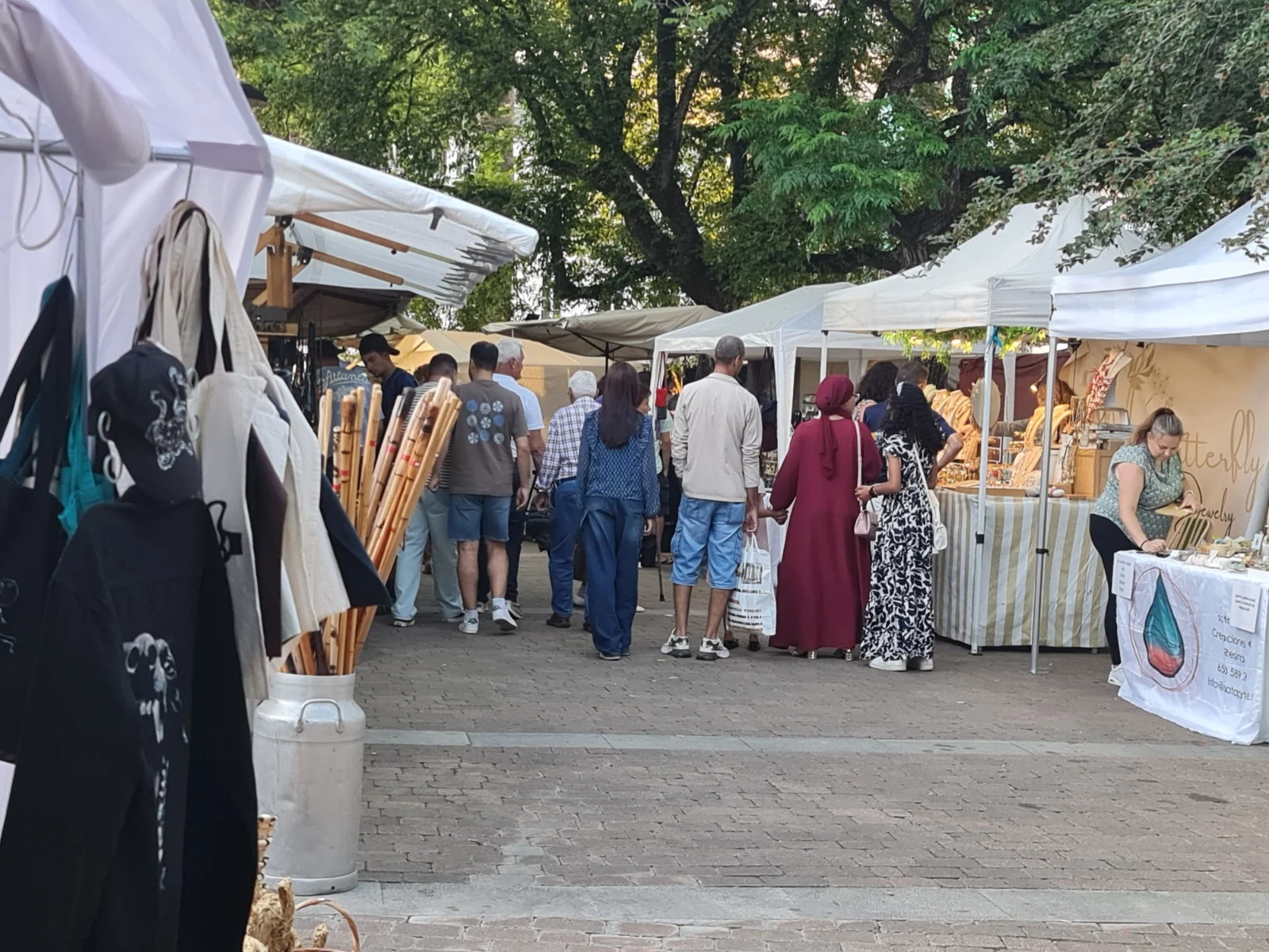 Visitantes entre puestos de artesanía y comercio local al aire libre
