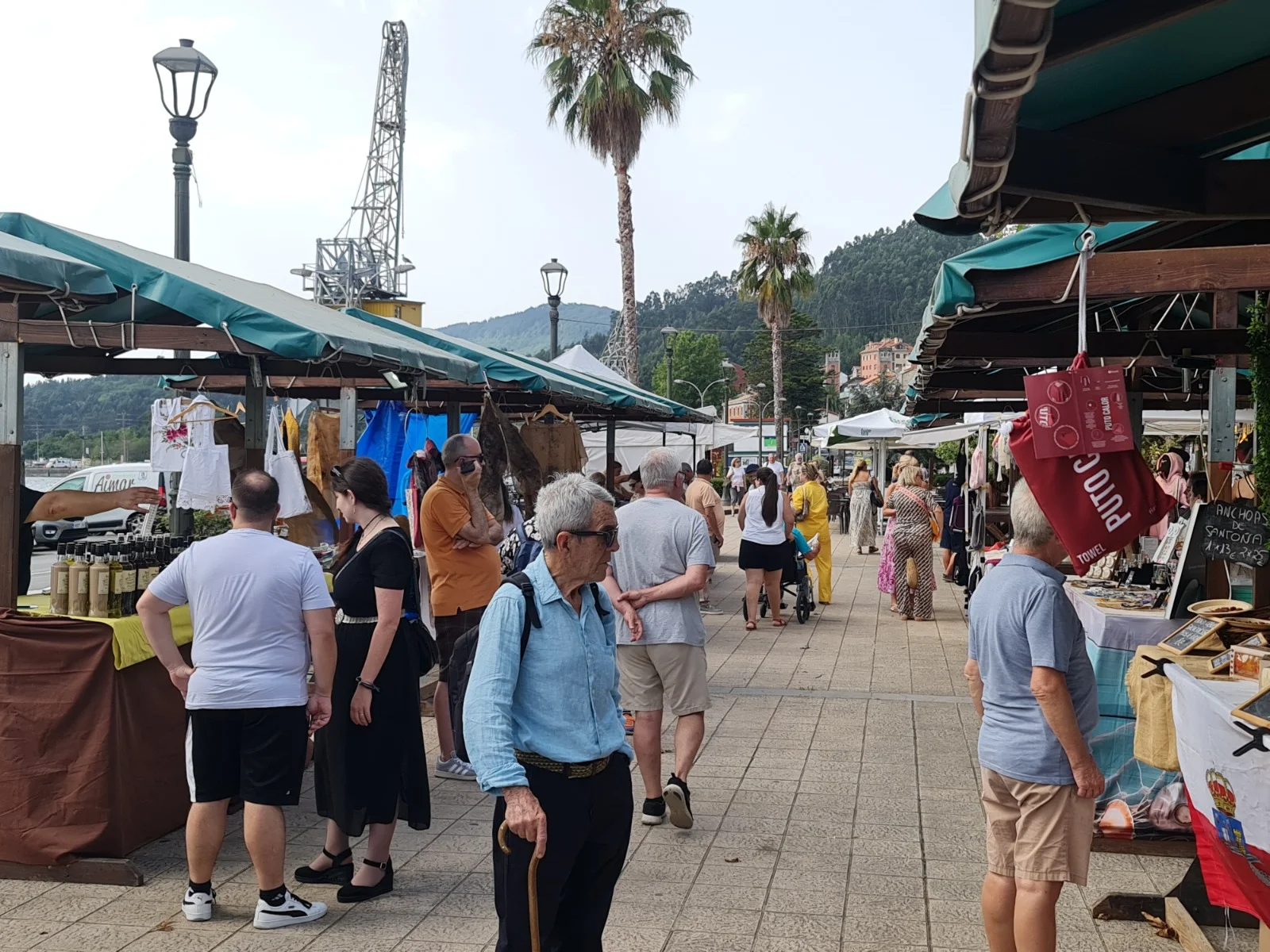 Puestos de artesanía y visitantes en un mercado marinero de Asturias
